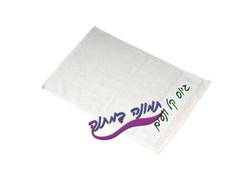 מגבת לבנה עם רקמה אישית בצידה מונחת על רקע לבן נקי